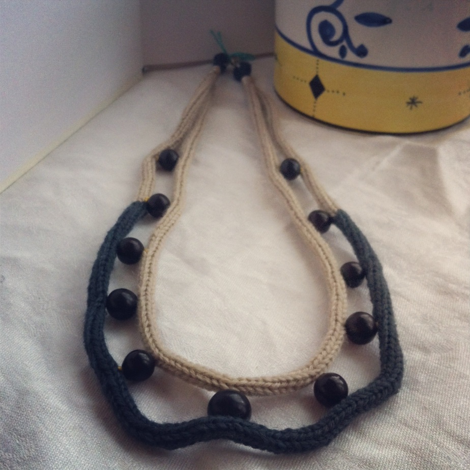 Grått/svart virkat halsband i ull med svarta pärlor